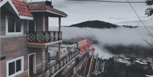 budynek z balkonem z mgłą w tle w obiekcie Le Grace Apoorva w mieście Kodaikānāl