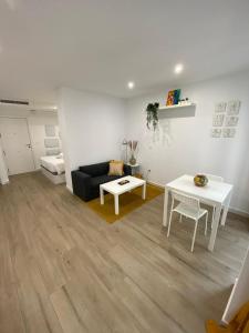 uma sala de estar com um sofá preto e uma mesa em Apartamentos Mercado Central em Valência