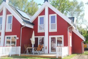 a red house with a white roof at Ferienhaus Wellenläufer Haus - Sauna, Terrasse, Garten in Glowe