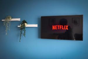 una pared azul con un televisor con las palabras netflix en Modern 1BR Gem - Stylish Flat in Harlow, en Great Parndon