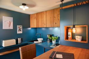 eine Küche mit blauen Wänden und einem Holztisch in der Unterkunft Ferienwohnung am Frohmarkt in Oberstdorf