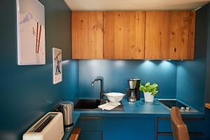 eine blaue Küche mit einem Waschbecken und Holzschränken in der Unterkunft Ferienwohnung am Frohmarkt in Oberstdorf