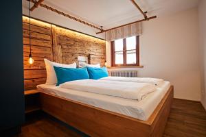 1 dormitorio con 1 cama grande con almohadas azules en Ferienwohnung am Frohmarkt, en Oberstdorf