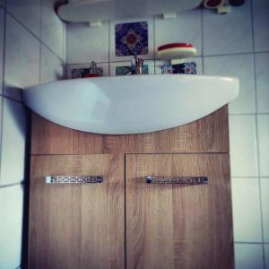 umywalkę na górze drewnianej szafki w łazience w obiekcie Σοφίτα " Μαργαρίτα " w mieście Tríkala