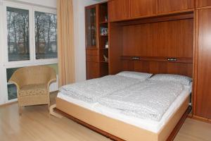 a bedroom with a bed and a cabinet and a chair at Likedeeler Weg 1 Whg 21 in Zingst