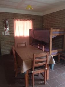 a dining room with a table and a bunk bed at Sierras Alojamiento in Mina Clavero