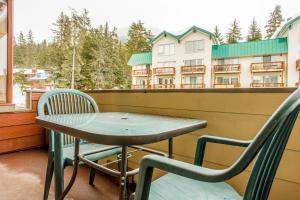 uma mesa e duas cadeiras numa varanda em Timberline Getaway em Girdwood