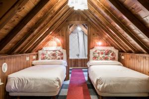 two beds in a room with a attic at Hotel SNÖ Colomers in Salardú