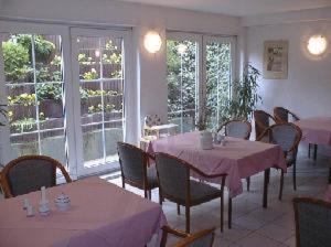 un comedor con mesas y sillas con mantel rosa en Waldhaus Mühlenbeck bei Berlin, en Mühlenbeck
