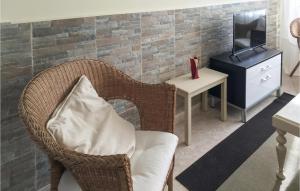 een woonkamer met een stoel met een kussen en een televisie bij Casa El Rosedal in Ladrido