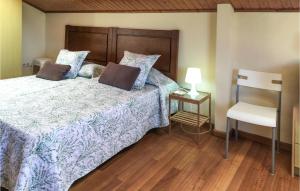 een slaapkamer met een bed met een houten hoofdeinde en een stoel bij Casa El Rosedal in Ladrido