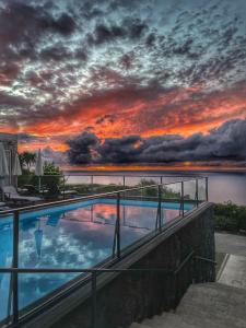 a swimming pool with a sunset in the background at Mosteiros Place in Mosteiros