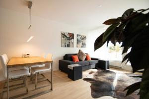 ein Wohnzimmer mit einem Sofa und einem Tisch in der Unterkunft Galerie Obersee 3E in Arosa