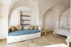ein Schlafzimmer mit einem Bett und einem Tisch in einem Zimmer in der Unterkunft Dimora Bellargo by BarbarHouse in Martina Franca