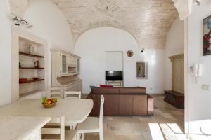ein Wohnzimmer mit einem Tisch und einem Sofa in der Unterkunft Dimora Bellargo by BarbarHouse in Martina Franca
