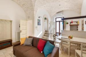 ein Wohnzimmer mit einem Sofa und einer Küche in der Unterkunft Dimora Bellargo by BarbarHouse in Martina Franca