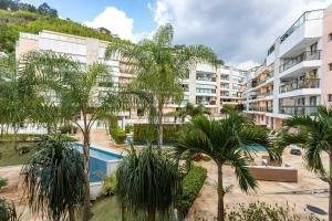 apartamentowiec z basenem i palmami w obiekcie Cobertura exclusiva com Jacuzzi Privativa no Coração de Itaipava w mieście Itaipava