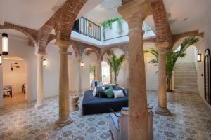a living room with columns and a blue couch at La Fonda Heritage Hotel Luxury, Relais & Châteaux in Marbella