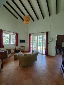 sala de estar con sofá, sillas y ventanas en Villa Luana Yuna, en Au Cap