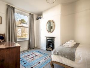a bedroom with a bed and a mirror and a fireplace at Pass the Keys Cosy home close to City Centre and University in Exeter