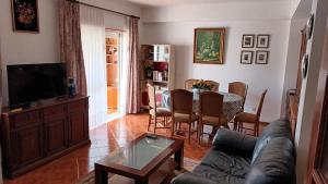 ein Wohnzimmer mit einem Sofa und einem Tisch in der Unterkunft familiahorta in Coimbra