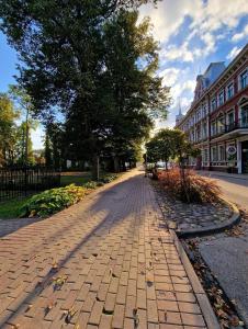 a cobblestone street with trees and a building at Center Apartments Tukums in Tukums