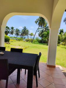 a table and chairs on a patio with a view of the ocean at Villa Luana Yuna in Au Cap