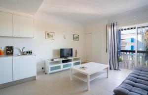ein weißes Wohnzimmer mit einem Sofa und einem Tisch in der Unterkunft Lago Azul 2 in Quarteira