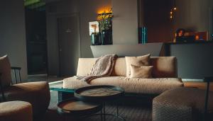 uma sala de estar com um sofá e duas mesas em Natiia Relais - Adults Only em Lazise