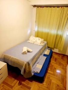 Un pequeño dormitorio con una cama con toallas. en Cómodo departamento 2 dormitorios Villa Devoto en Buenos Aires
