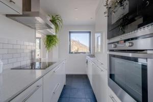 a kitchen with white appliances and a window at Peaceful 2 Bedroom Flat with Roof Terrace - Hackney in London