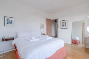a white bedroom with a large white bed in it at Peaceful 2 Bedroom Flat with Roof Terrace - Hackney in London