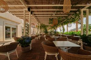 um restaurante com mesas, cadeiras e plantas em Hotel Osejava em Makarska