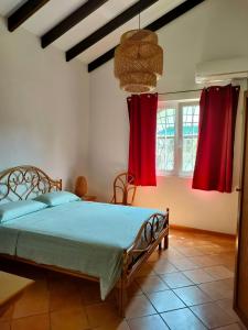 a bedroom with a bed with red curtains at Villa Luana Yuna in Au Cap
