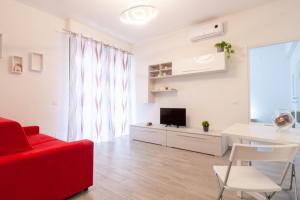 a living room with a red couch and a table at Appartamento Bilocale TA in Follonica