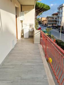 a balcony with a red fence and a street at Appartamento Bilocale TA in Follonica