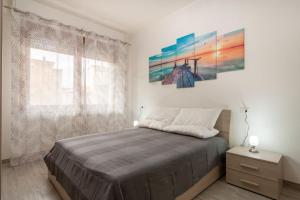 a bedroom with a bed and a painting on the wall at Appartamento Bilocale TA in Follonica
