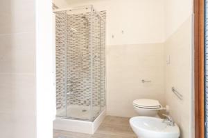 a bathroom with a shower and a toilet at Appartamento Bilocale TA in Follonica +10 photos