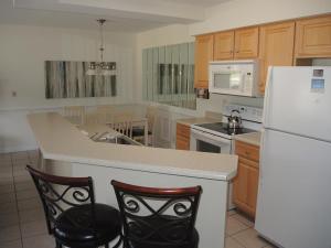 a kitchen with a white refrigerator and two chairs at Close to Beach Brunswick Plantation Condo 2302M with 27 Hole Golf Course Onsite condo in Calabash