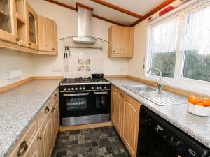 a kitchen with a stove and a sink at The Goodwood Annex in Chichester