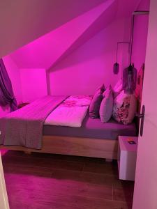 a bedroom with a bed with pink lighting at Kerschbaumer.Apartments in Waidhofen an der Ybbs