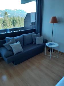 a blue couch in a living room with a large window at Gipfelsieg am Hallstättersee in Bad Goisern