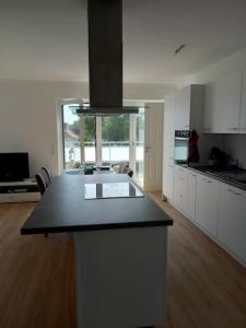 a kitchen with white cabinets and a black counter top at Große Moderne Penthouse Wohnung Mit Dachterrasse in Uetersen