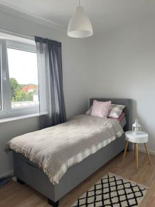 a small bedroom with a bed and a window at Große Moderne Penthouse Wohnung Mit Dachterrasse in Uetersen