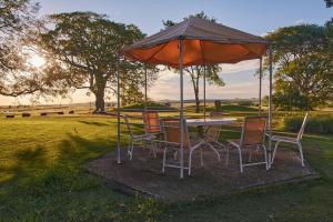 una mesa y sillas bajo una sombrilla en un campo en Campo & Golf en Victoria