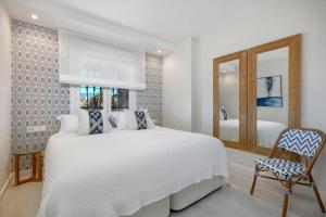 - une chambre avec un grand lit blanc et un miroir dans l'établissement New & Beautiful Apt walk to the beach - RDR251, à Marbella
