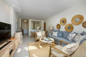 - un salon avec un canapé bleu et une table dans l'établissement New & Beautiful Apt walk to the beach - RDR251, à Marbella