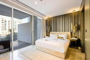 a bedroom with a bed and a large window at Five Palm - Residential 2 BR Suite with Private Beach -Livbnb in Dubai