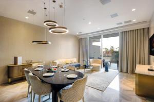 a dining room and living room with a table and chairs at Five Palm - Residential 2 BR Suite with Private Beach -Livbnb in Dubai