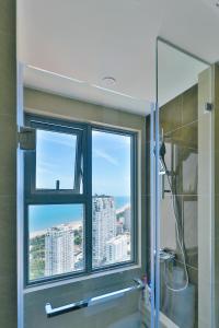 La salle de bains est pourvue d'une fenêtre et d'une douche avec vue. dans l'établissement MeoMeo Homestay - The Sóng Apartment, à Vung Tau